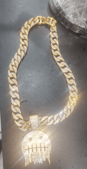 There is a large gold plated chain with a pendant